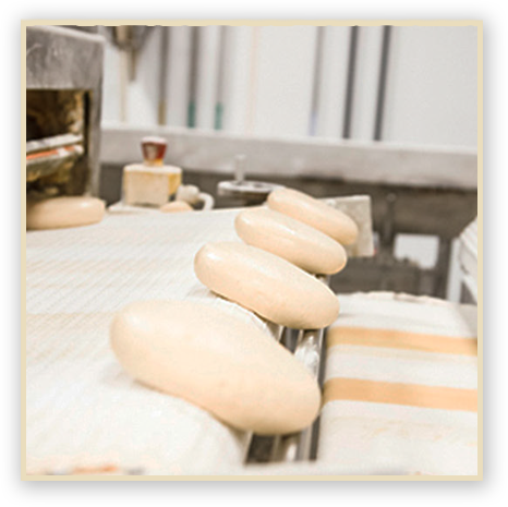 Pizza dough being moved on a conveyor belt